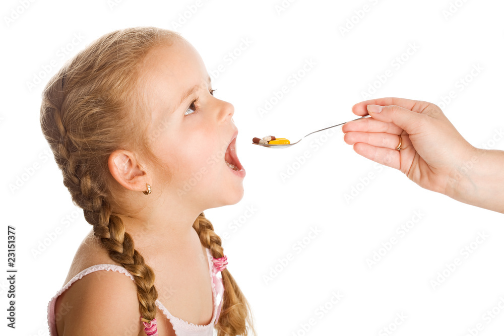 Drug abuse - little girl taking pills with spoon Drug abuse - little girl taking pills with spoon