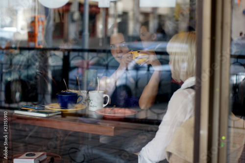 Girls in cafe. The photo through glass