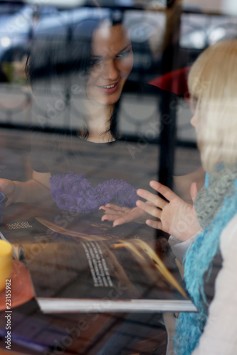 Girls in cafe. The photo through glass