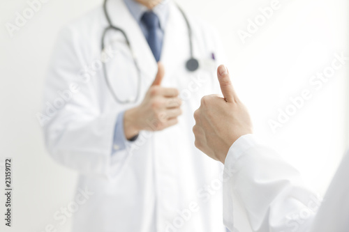 親指を立てる男女の医師