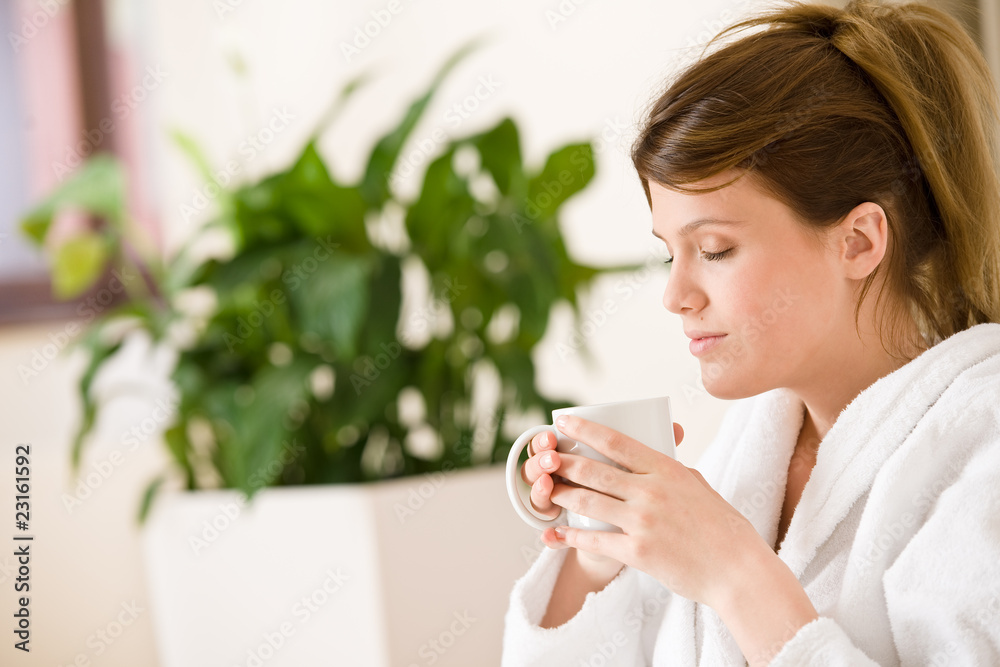 Young woman in white bathrobe with coffee Young woman in white bathrobe with coffee