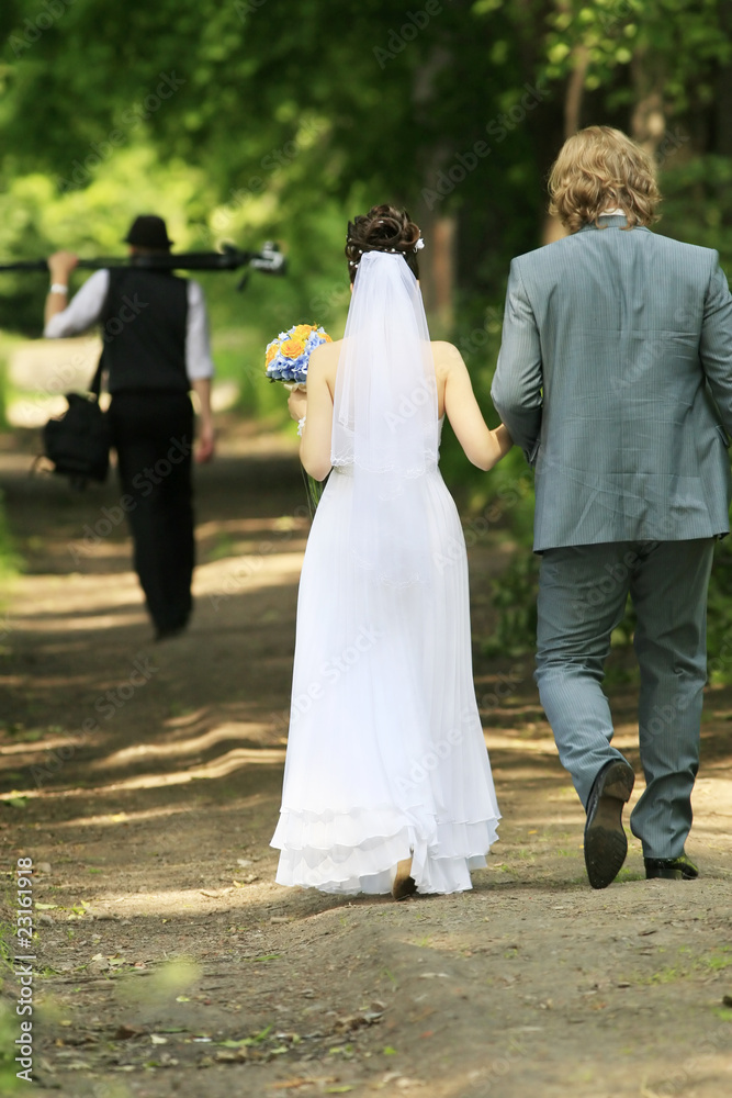 Bride,bridegroom and wedding photographer in city park Bride,bridegroom and wedding photographer in city park