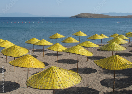 Fototapeta Naklejka Na Ścianę i Meble -  yellow sun umbrellas at the beach