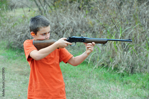 Boy firing rifle