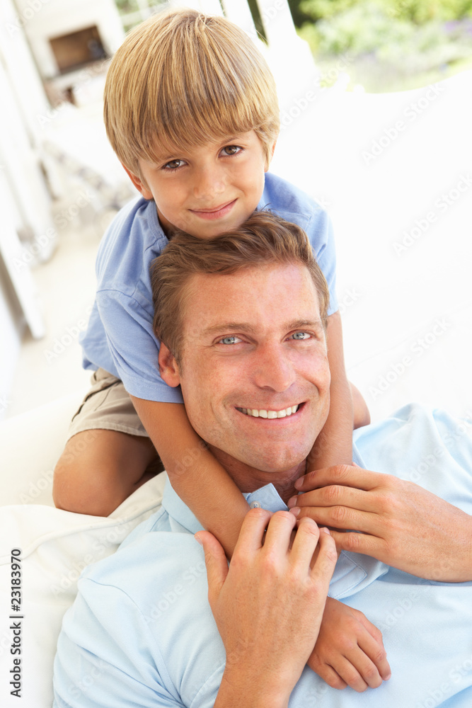 Fototapeta premium Portrait Of Father And Son Relaxing On Sofa