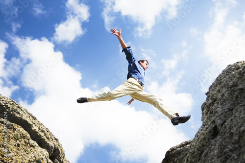 Businessman jumping over the mountains, business concept