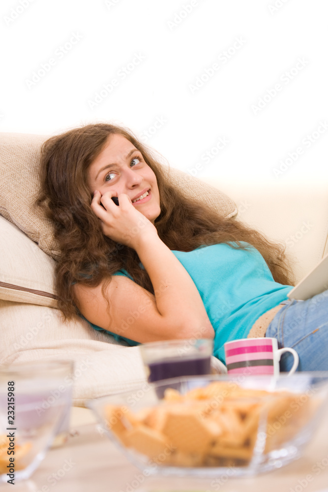 Attractive young girl lying on sofa and talking on phone Attractive young girl lying on sofa and talking on phone