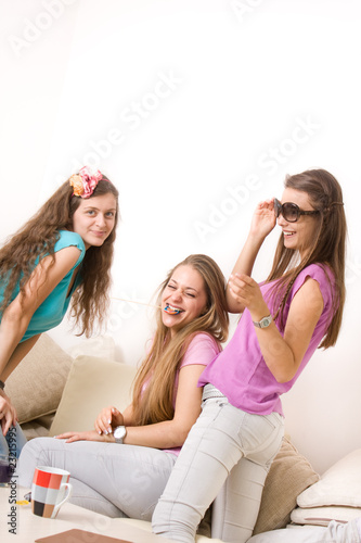 Three young girls laughing and having fun in the living room