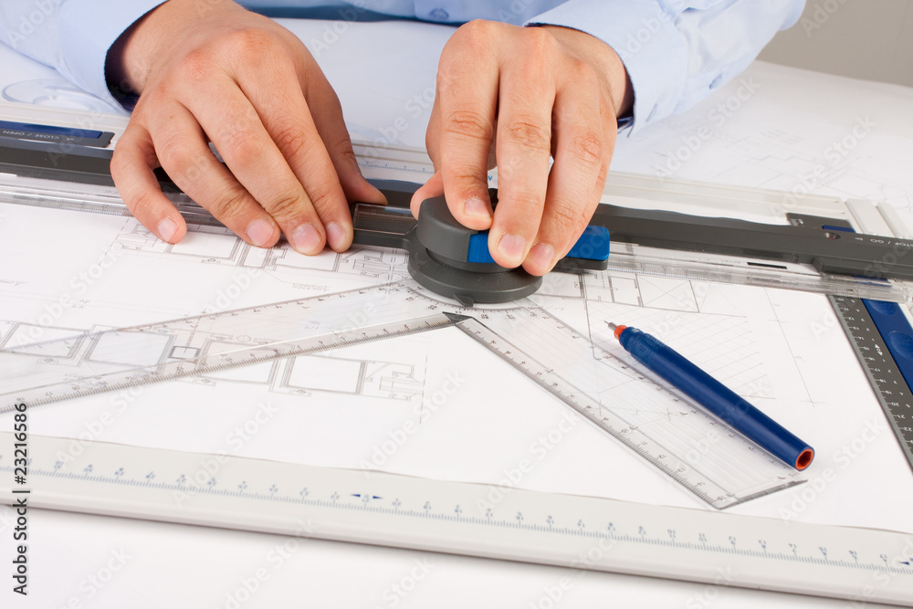 Architect working on architectural plans in the office Architect working on architectural plans in the office