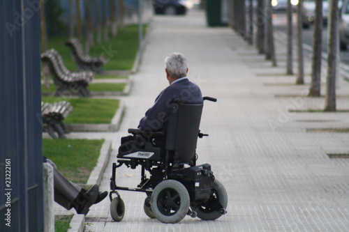 Minusvalido, sin piernas, en silla de ruedas descansando.