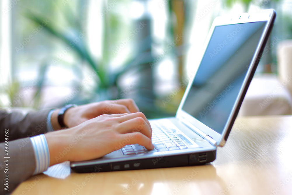 Person Typing on a modern laptop in an office Person Typing on a modern laptop in an office
