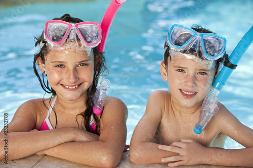 Boy and Girl In Swimming Pool with Goggles and Snorkel