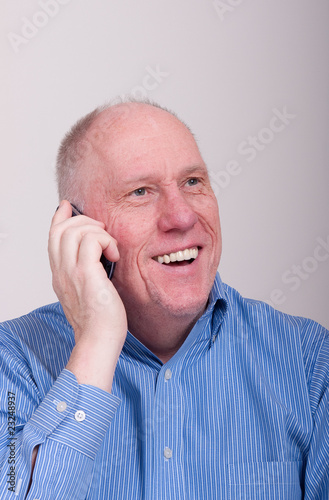 Older Balding Man in Blue Shirt Very Happy on Phone