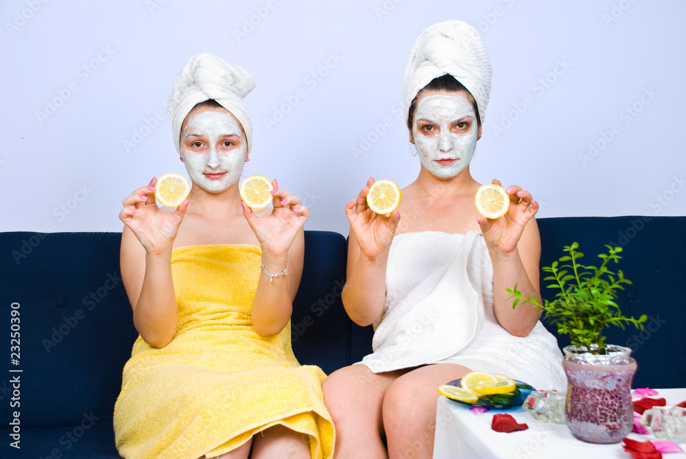 Woman with facial mask showing slices lemon Woman with facial mask showing slices lemon