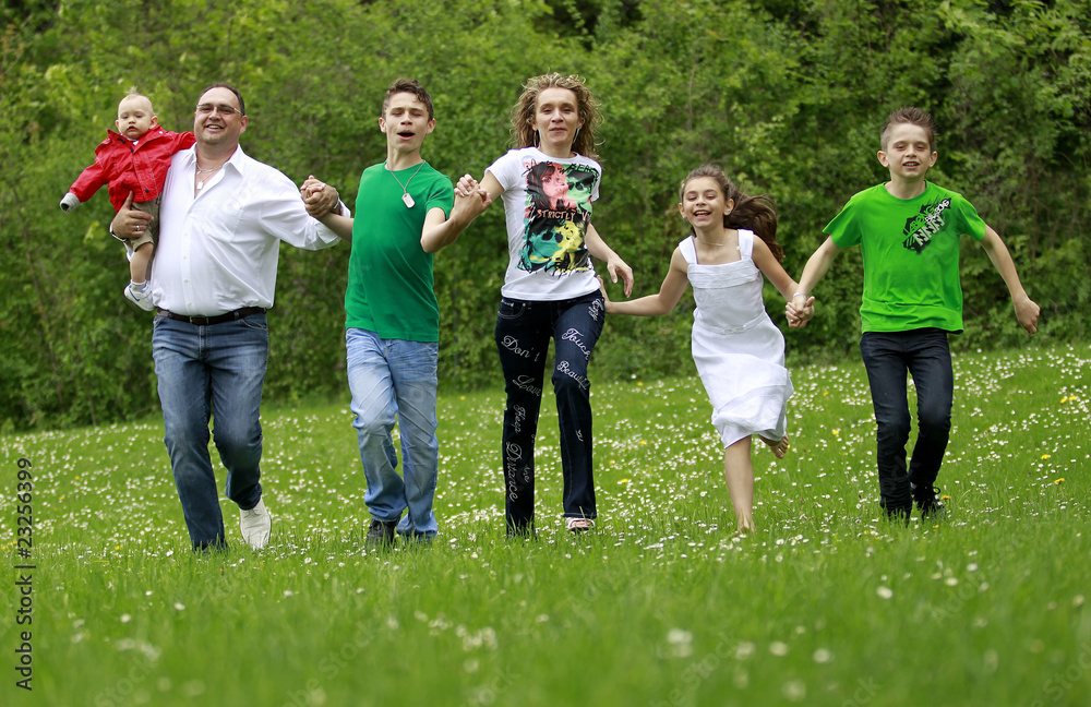 Familie laeuft auf einer Wiese