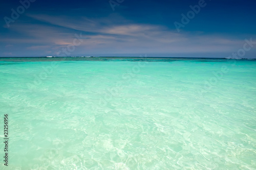 Cyan ocean under blue sky with clouds © Alexander Kosarev