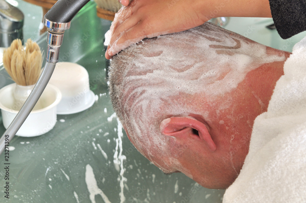 Fototapeta premium Customer's head being washed after haircut at barber shop.