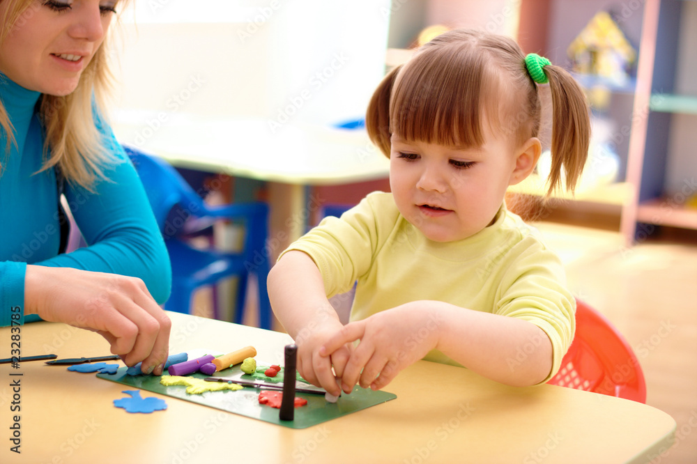 Teacher and little girl play with plasticine Teacher and little girl play with plasticine