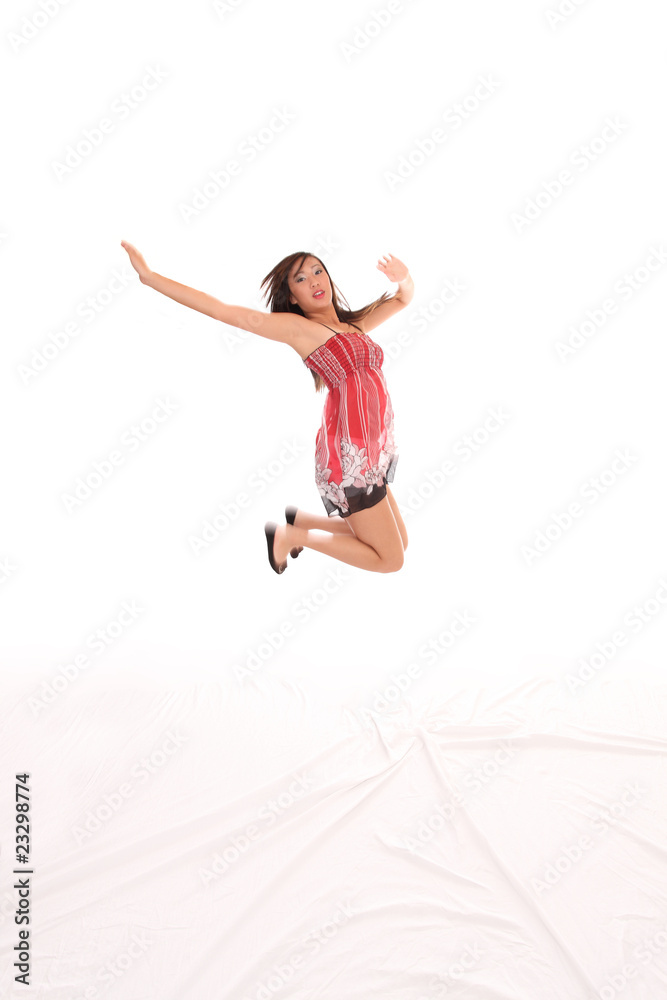 Young Asian American teen woman jumping red dress