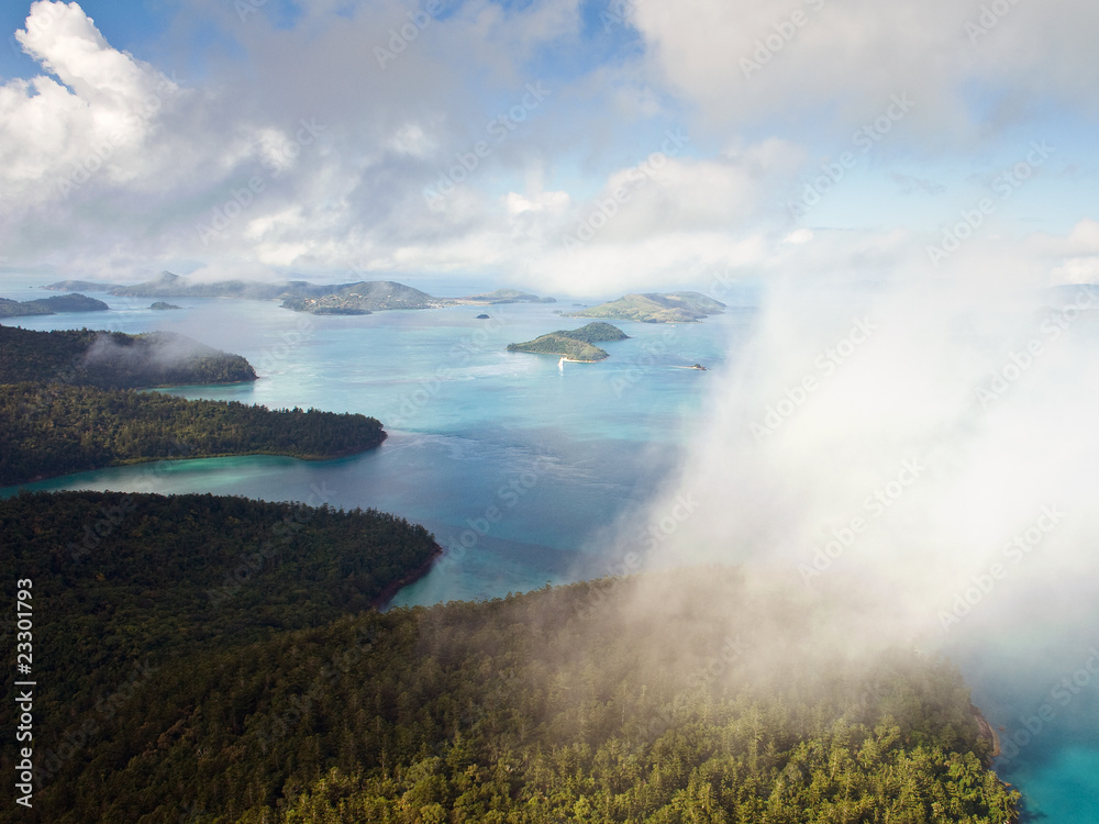 Aerial view of the Whitsunday Islands through misty clouds