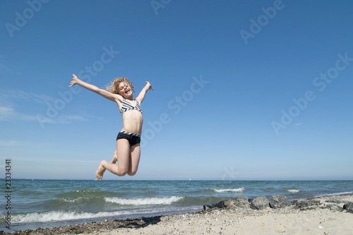 Girl jumping on the beach. Hapiness concept