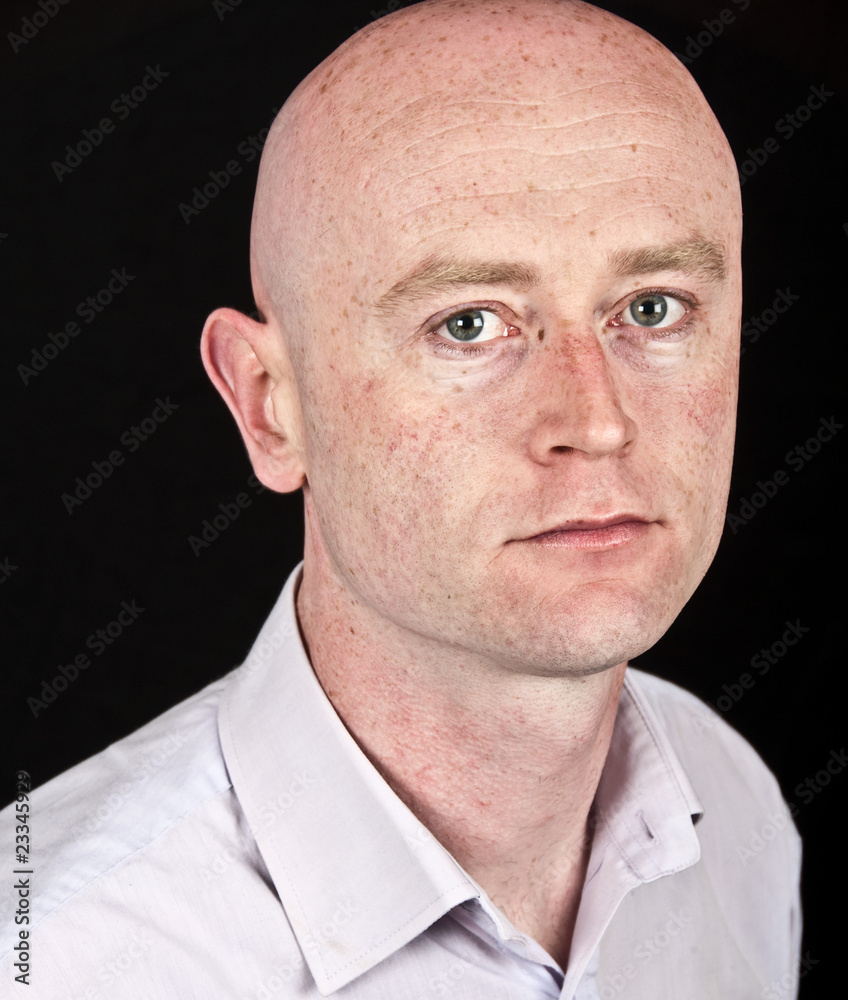 male in his 30's in shirt on black back drop