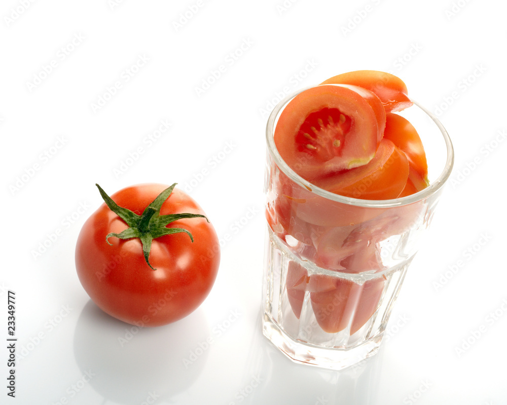 Tomato and slices in glass isolated on white background Tomato and slices in glass isolated on white background