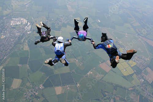 Skydivers in freefall holding hands