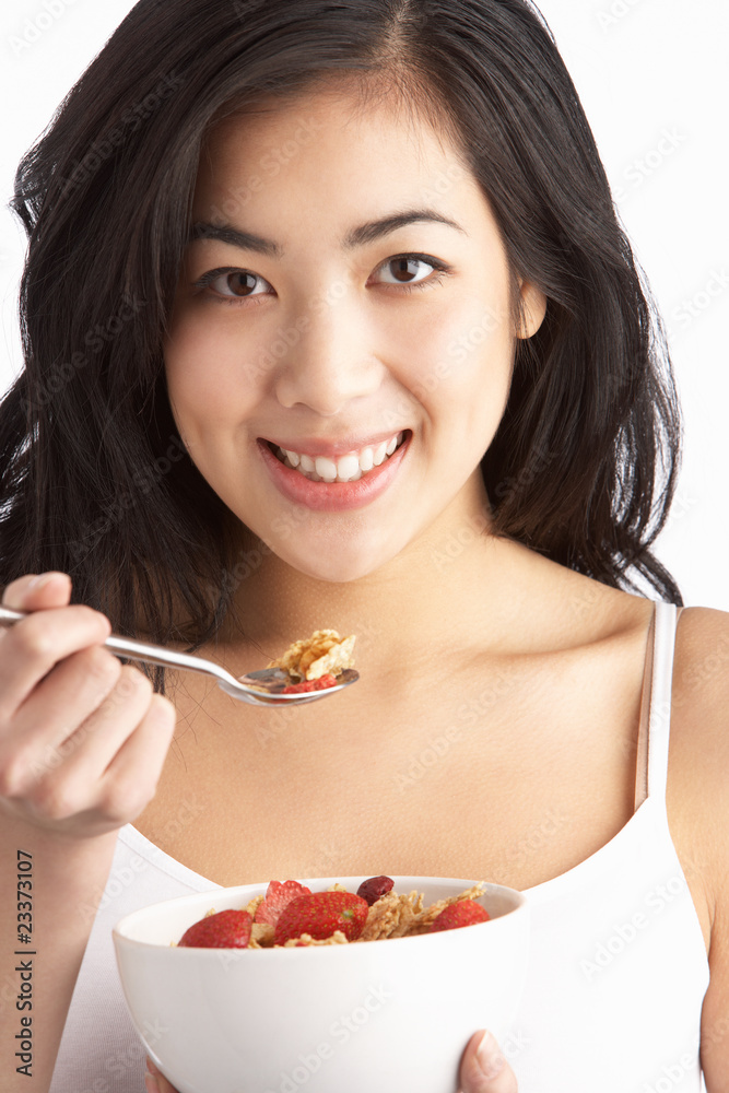 Young Woman Eating Bowl Of Healthy Breakfast Cereal In Studio Young Woman Eating Bowl Of Healthy Breakfast Cereal In Studio