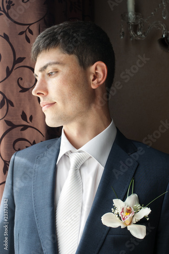 Vászonkép Handsome groom with orchid flower in buttonhole