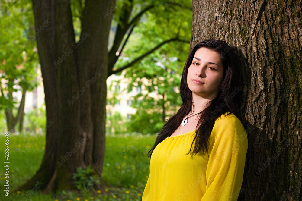 Beautiful woman standing by the tree Beautiful woman standing by the tree