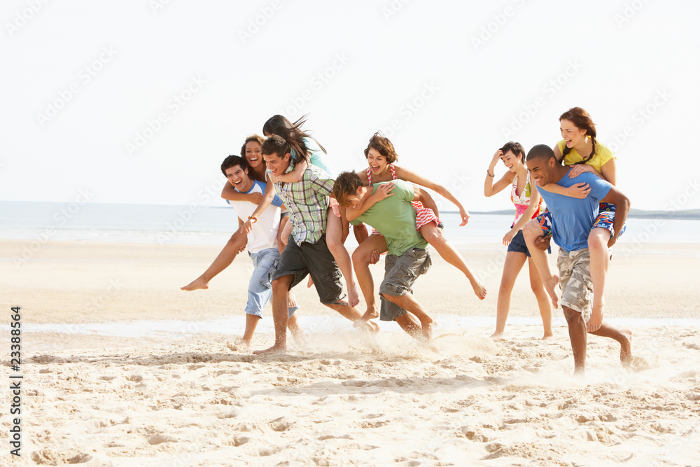 Group Of Friends Running Along Beach Together