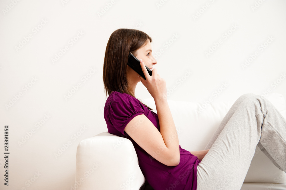 junge frau sitzt auf sofa und telefoniert, lacht junge frau sitzt auf sofa und telefoniert, lacht