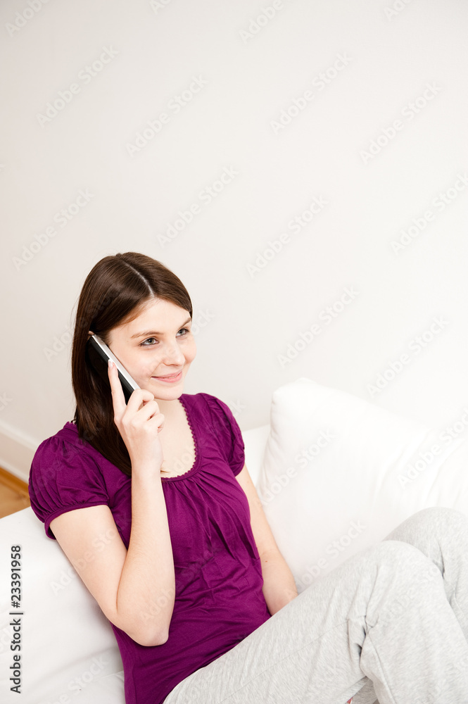 junge frau sitzt auf sofa und telefoniert, lacht junge frau sitzt auf sofa und telefoniert, lacht