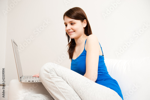 junge frau entspannt sich zu hause auf sofa mit laptop