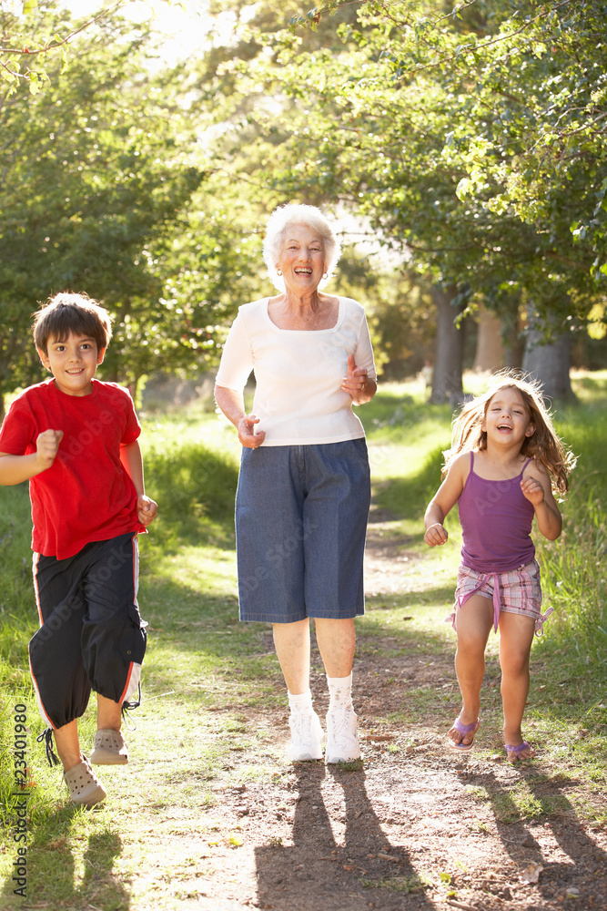 Fototapeta premium Grandmother Jogging In Park With Grandchildren