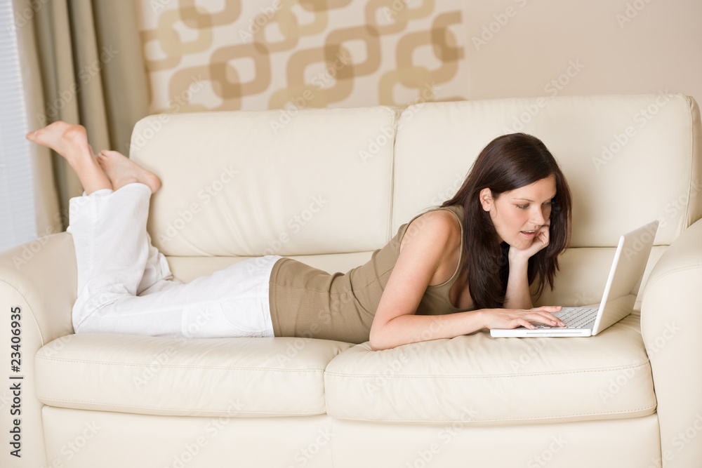 Young woman with laptop on sofa home Young woman with laptop on sofa home