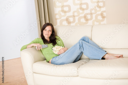 Woman watching television with popcorn in living room