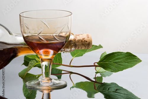 Glass of red wine near wine bottle photo