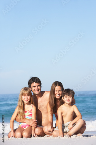 Young Family Relaxing On Beach Holiday © Monkey Business