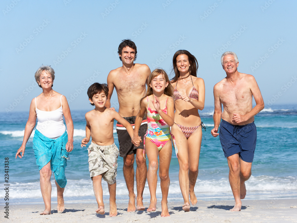 Three Generation Family On Holiday Walking Along Beach Three Generation Family On Holiday Walking Along Beach