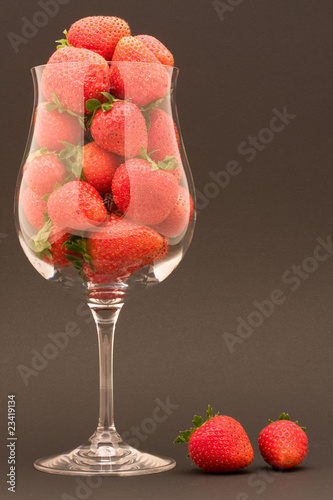 Bicchiere di fragole con due fragole appoggiate photo