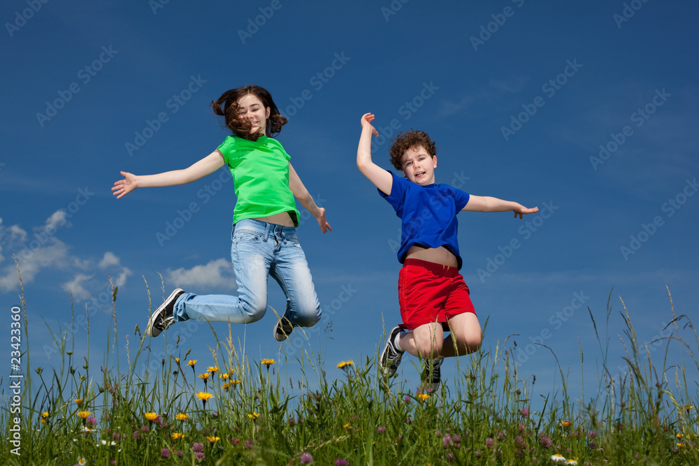 Girl and boy jumping, running against blue sky Girl and boy jumping, running against blue sky