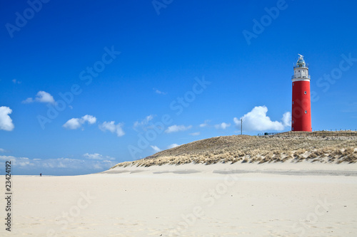 Lighthouse in the dunes at the beach photo