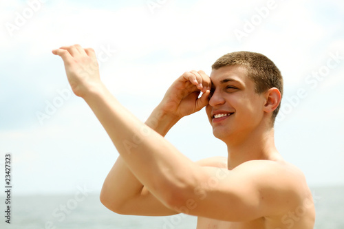 Happy young man looking through his fingers