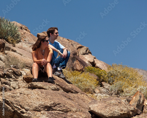 Hikers in desert look at distant object