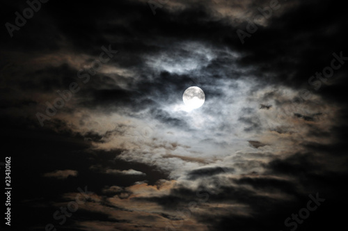 Full moon and white clouds on black night sky