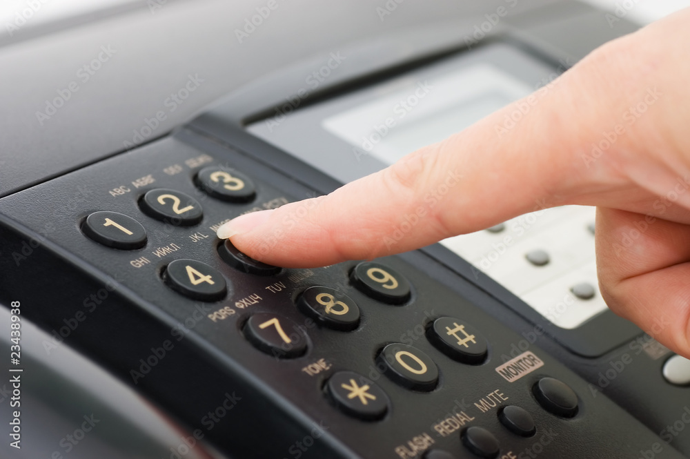The hand presses the fax button The hand presses the fax button