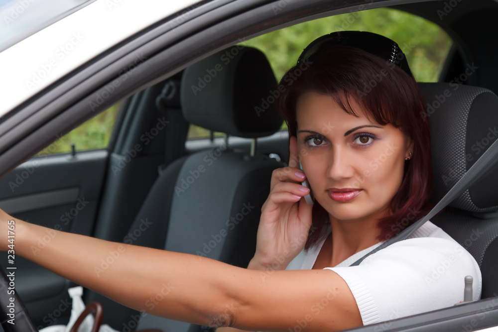 Woman sitting in a  car and talking by mobile telephone