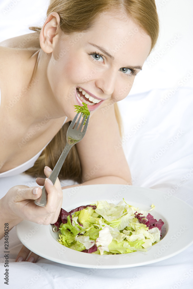 portrait of lying down woman eating salad portrait of lying down woman eating salad